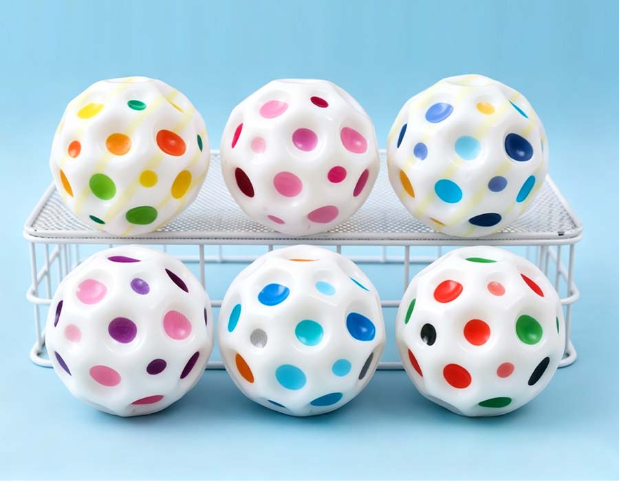Pelota perforada multicolor — juguete elástico blanco